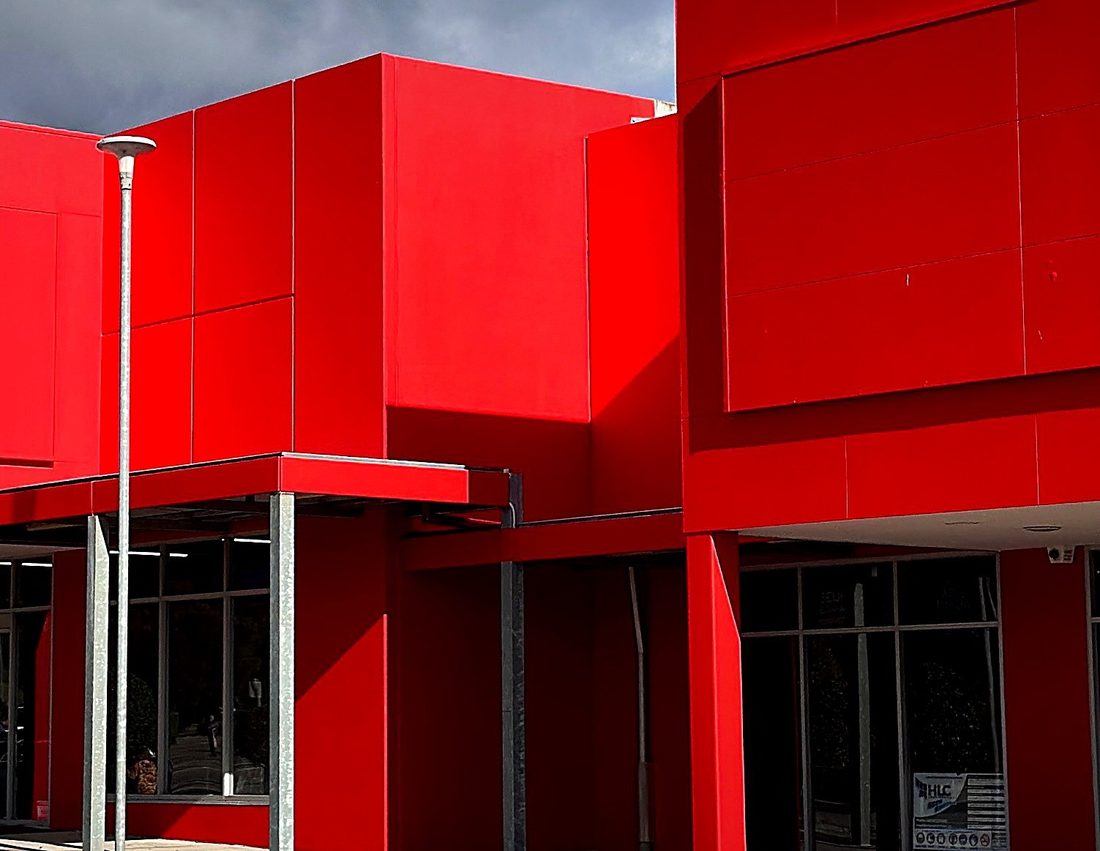 Bold red commercial façade coating — completed